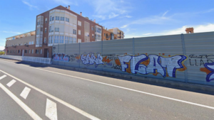 Pantalla acústica en Benifaraig con graffiti y edificios al fondo