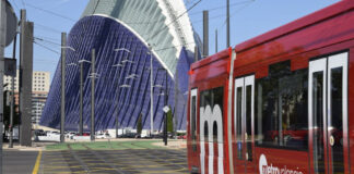 Tram de la línea 10 de Metrovalencia frente a un edificio moderno