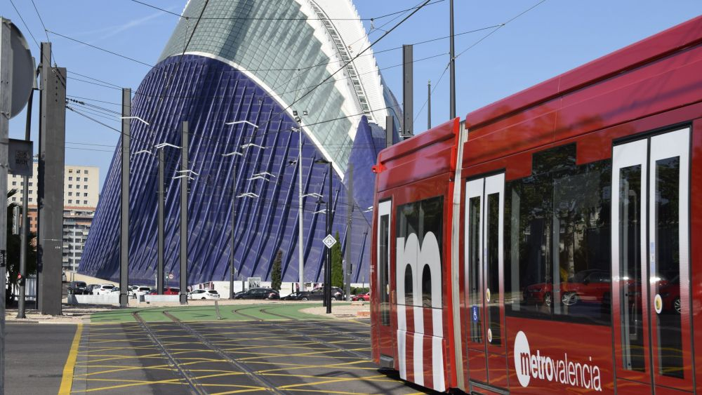 Tram de la línea 10 de Metrovalencia frente a un edificio moderno