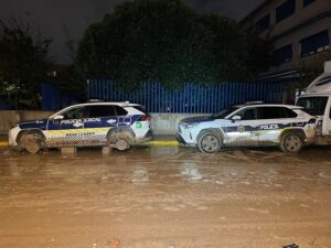 Dos vehículos de policía local en Benetússer en una calle embarrada