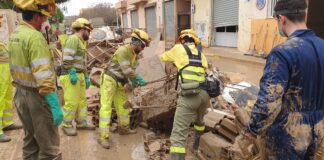 Trabajadores limpiando alcantarillado tras inundación con barro y escombros