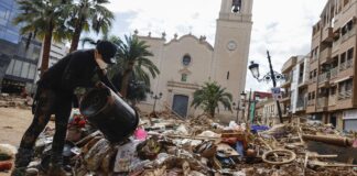 Persona limpiando escombros tras inundación en Paiporta
