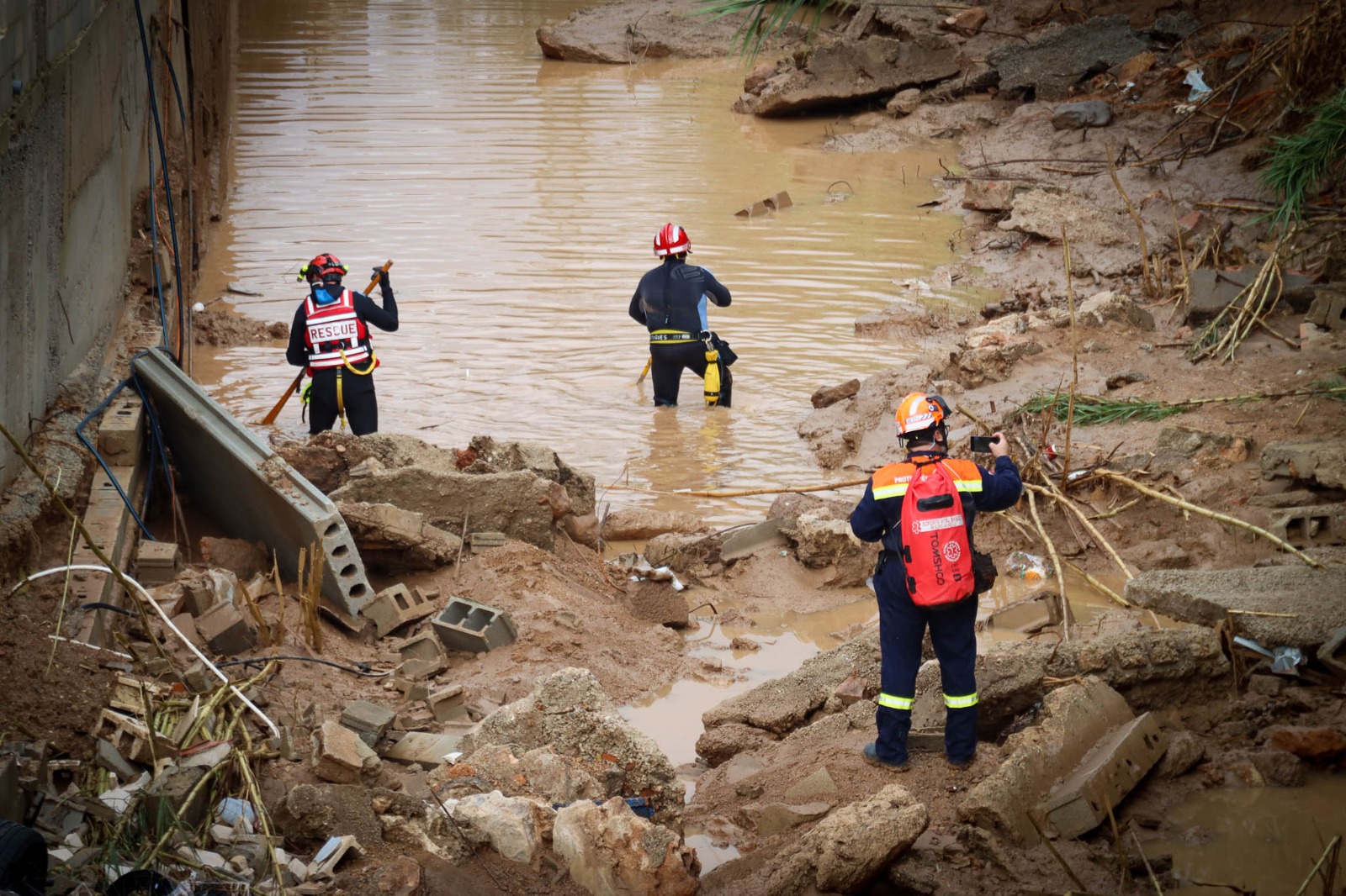 Rescatistas trabajando en un barranco inundado buscando desaparecidos