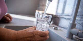 Persona llenando un vaso con agua potable del grifo en Valencia