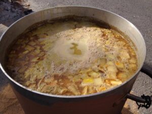 Gran olla con caldo hirviendo y trozos de ingredientes visibles