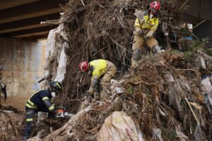 Bomberos trabajando en la limpieza de escombros tras una inundación
