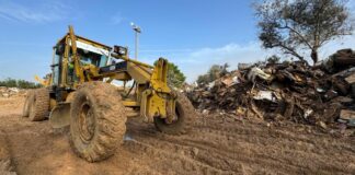 Máquina de construcción en un terreno con lodo y escombros