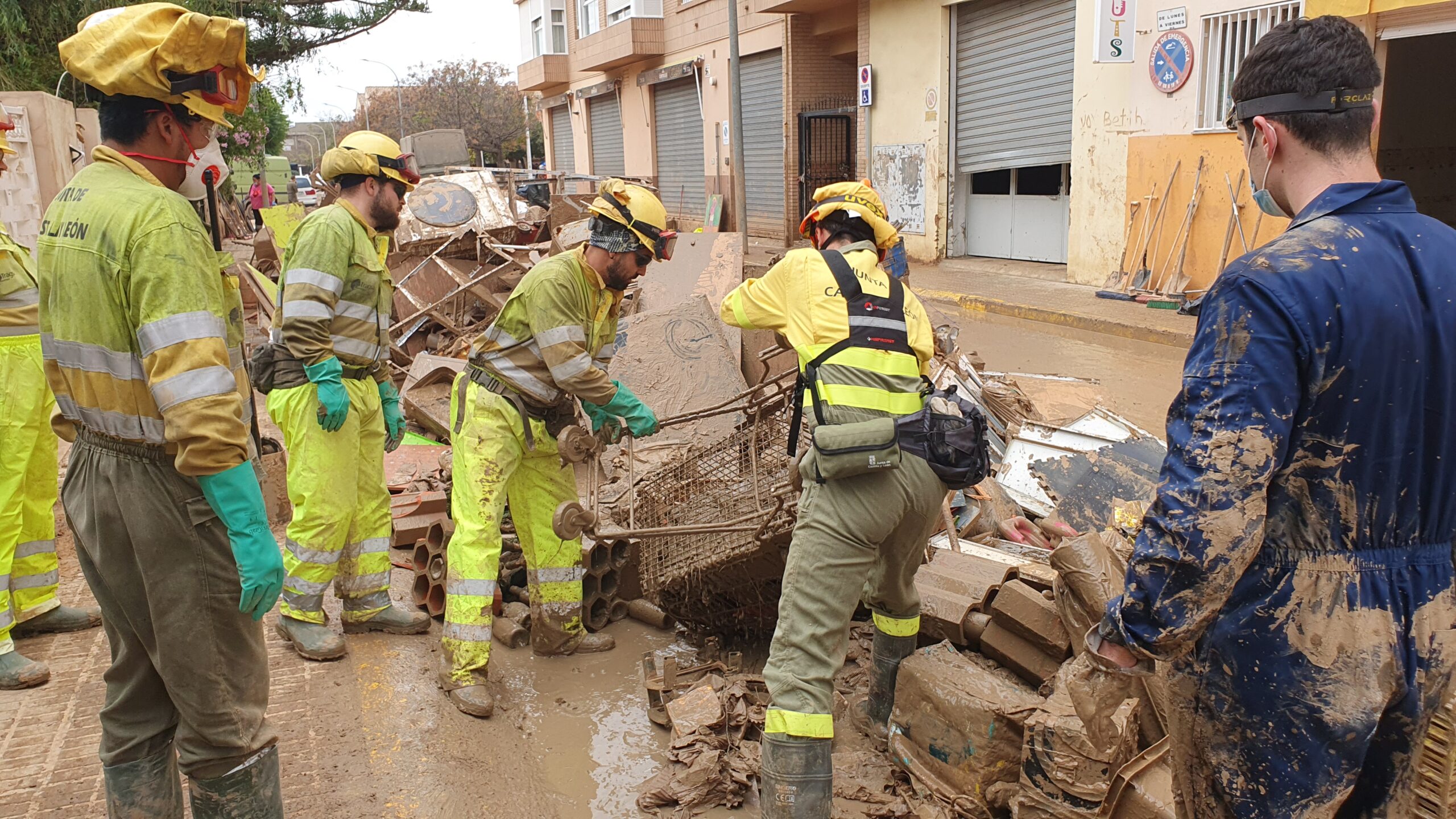 Trabajadores limpiando lodos en una zona afectada por inundaciones