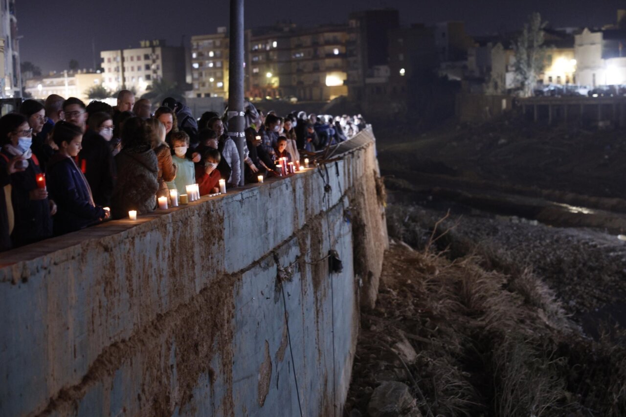 Asistentes portan velas en el homenaje en el barranco del Poyo a los fallecidos por la dana que arrasó parte de la zona, cuando se cumple un mes de la catástrofe.