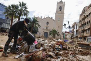 Persona limpiando escombros tras inundación en Paiporta