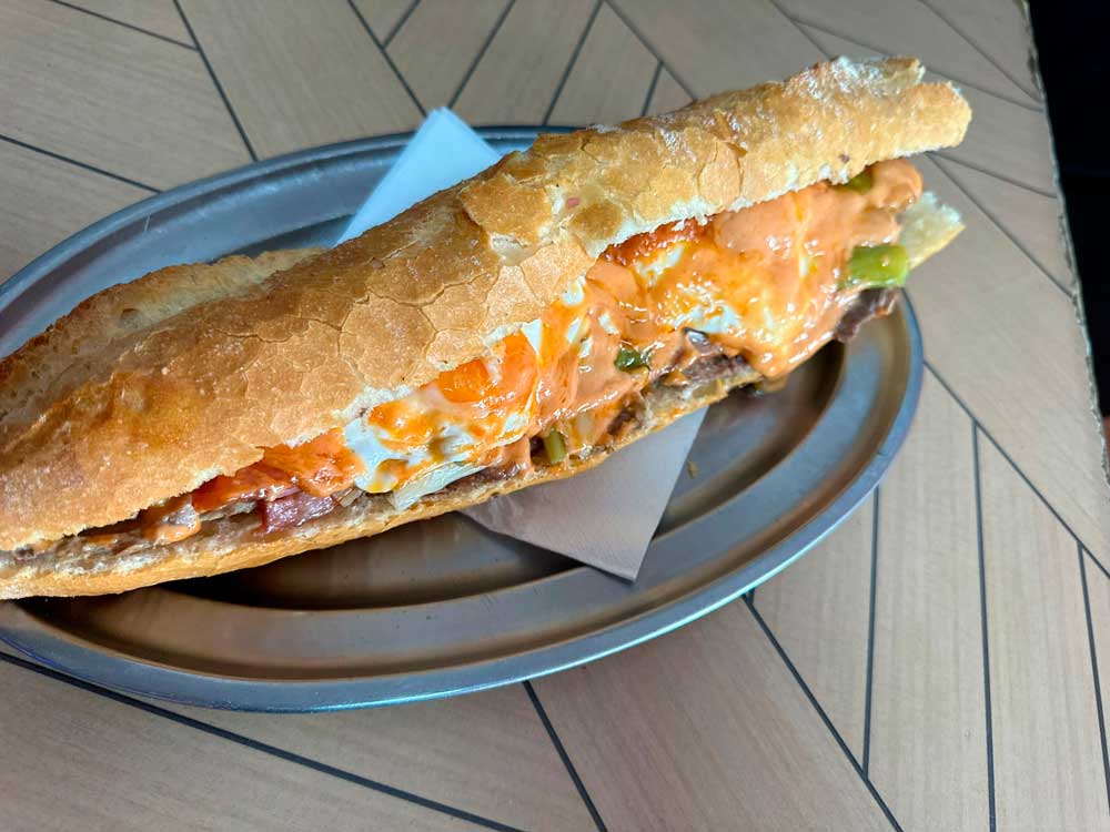 Entrepà d'allioli, carn de cavall, ou i bacon servido en un plat