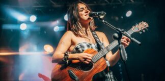 Cantautora Esther actuando en un concierto solidario con guitarra