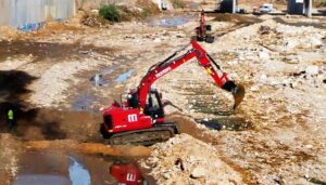 Máquina excavadora realizando trabajos de limpieza en el barranco entre Paiporta y Picanya