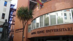 Edificio del Hospital Clínico Universitario de Valencia con palmera y escultura