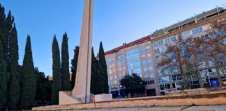 Monumento a las víctimas de las riadas en Valencia con árboles y edificios de fondo