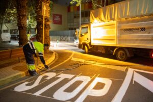 Trabajador pintando una señal de stop en la calle Lloma Llarga