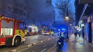 Incendio en un bingo en el centro de Valencia con humo y bomberos.