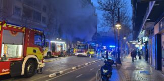 Incendio en un bingo en el centro de Valencia con humo y bomberos.