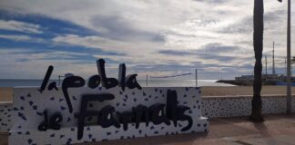 Cartel de La Pobla de Farnals junto a la playa y el mar