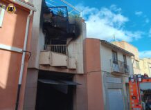 Edificio dañado por incendio en Alfafar con bomberos presentes