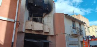 Edificio dañado por incendio en Alfafar con bomberos presentes
