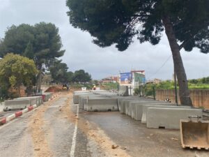 Obras de reconstrucción del puente en Picanya con maquinaria y bloques de hormigón.