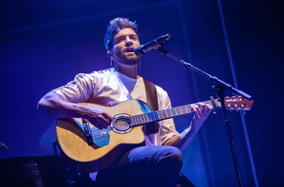 Pablo Alborán cantando en un concierto con guitarra