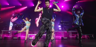 Sebastián Yatra actuando en un concierto con luces de fondo