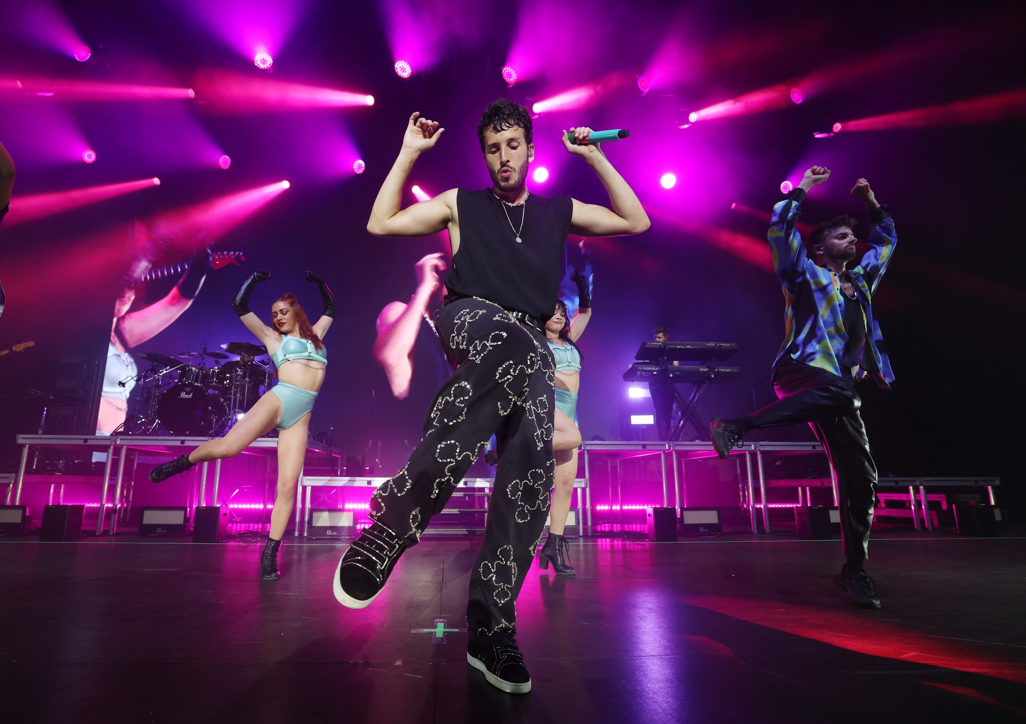 Sebastián Yatra actuando en un concierto con luces de fondo