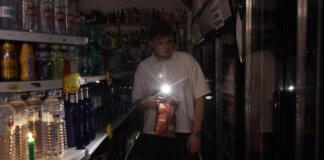 Una persona utiliza su teléfono móvil como linterna en un ultramarinos en Valencia, este lunes, con motivo del apagón de suministro eléctrico. El apagón eléctrico generalizado ha obligado a los bomberos de la provincia de Valencia a realizar ya más de ochenta servicios por rescates en ascensores, según fuentes de este cuerpo de seguridad.