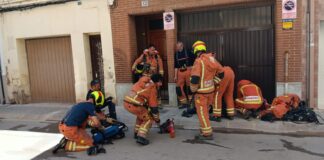 Bomberos trabajando en un incendio en Benetússer con equipos de protección