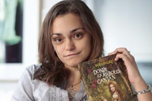Laura Gallego sosteniendo su libro 'Donde los árboles cantan'