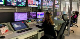 Mujer trabajando en un control de televisión con múltiples pantallas