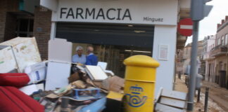Montón de escombros frente a una farmacia en Paiporta tras la DANA