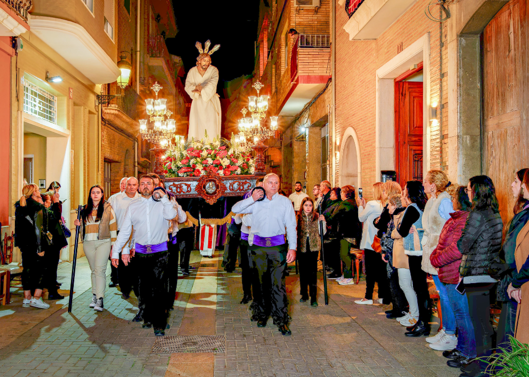 Participantes en la procesión de Semana Santa en Alboraya con un paso religioso.
