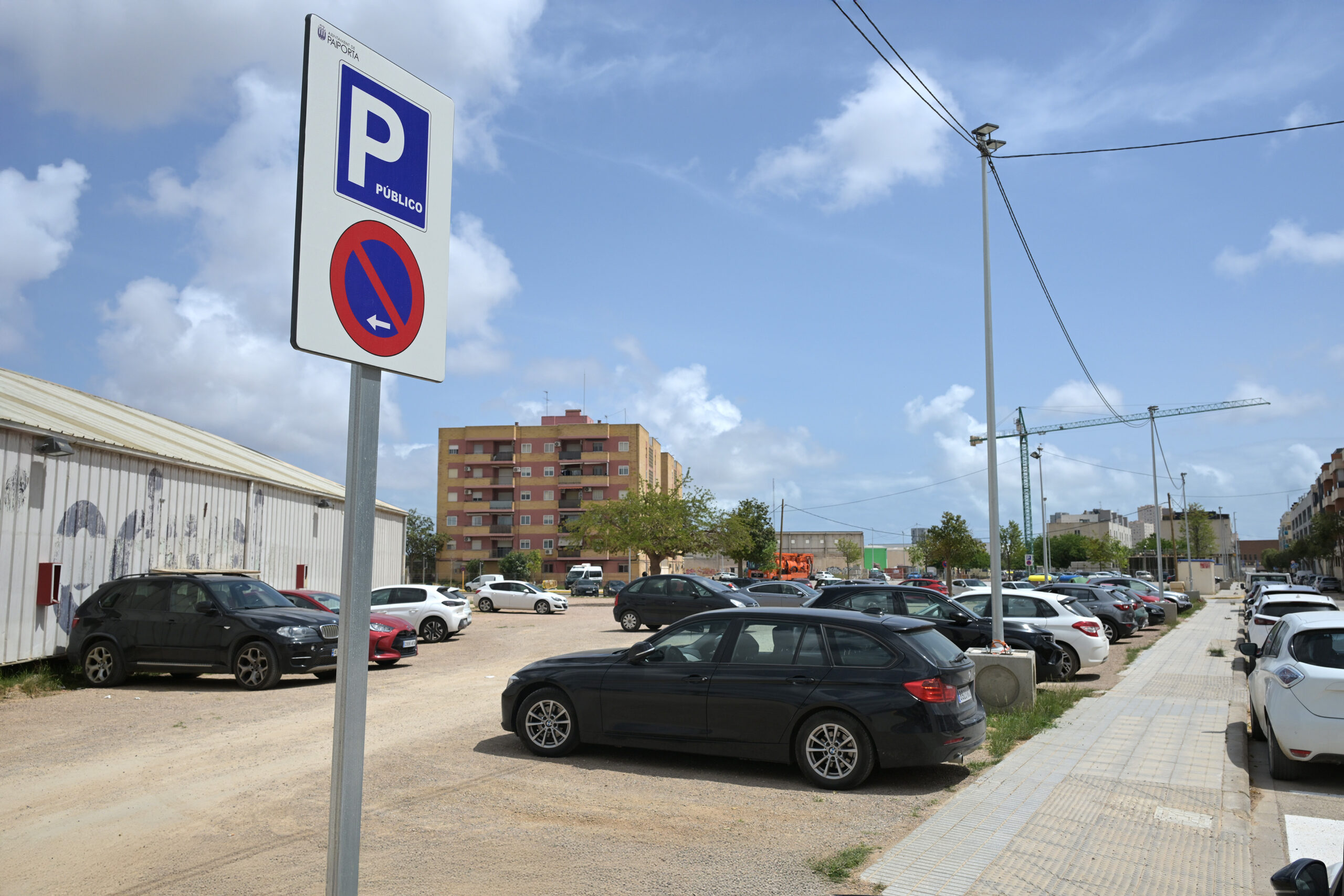 Aparcamiento público en Paiporta con señalización visible y vehículos estacionados.