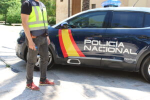 Agente de la Policía Nacional junto a un coche patrulla en Torrent