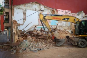 Excavadora trabajando en la demolición de un edificio en Torrent