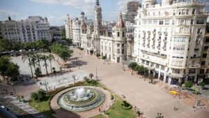 Vista de la plaza del Ayuntamiento de València con fuente y edificios históricos.
