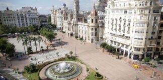 Vista de la plaza del Ayuntamiento de València con fuente y edificios históricos.