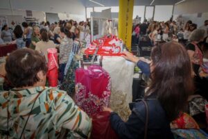 Visitantes explorando telas y moda en el Showroom Faller de Torrent