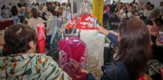 Visitantes explorando telas y moda en el Showroom Faller de Torrent