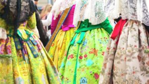 Vestidos tradicionales de falleras en Valencia con colores vibrantes.