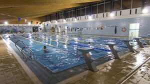 Interior de la piscina d'Aiora amb nadadors i equipament de climatització