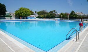 Piscina de Burjassot con agua cristalina y vegetación alrededor
