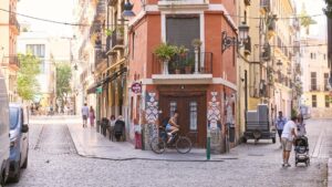 Calle en València con personas y bicicletas en un día soleado