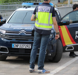 Agente de la Policía Nacional junto a un vehículo policial en Valencia