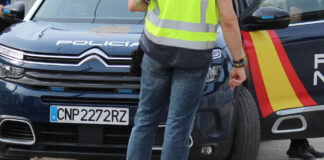 Agente de la Policía Nacional junto a un vehículo policial en Valencia