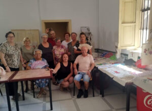 Grupo de mayores en la escuela de verano de Museros realizando manualidades