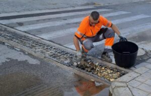 Trabajador limpiando un imbornal en Paterna para prevenir inundaciones
